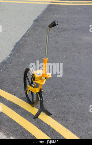 Roue du géomètre ou molette cliquable permet de mesurer des distances sur des routes ou des trottoirs par la route ou l'utilité de l'entretien Banque D'Images