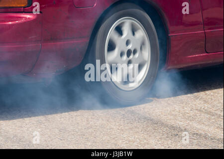 Voiture d'entraînement de roue arrière des pneus en feu pour réchauffer Banque D'Images