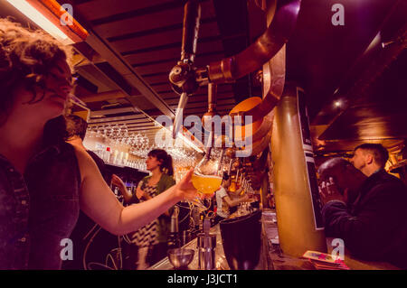 Bruxelles, Belgique - 11 août, 2015 : barman au bar de la bière en tapotant le délire grand verre avec plusieurs autres robinets à côté. Banque D'Images