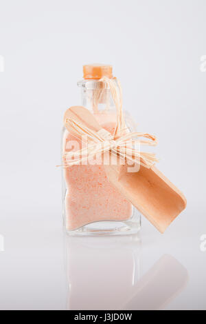 Bouteille de sel de bain de l'himalaya rose sur une surface blanche. Le sel de bain de l'himalaya isolé sur fond blanc. Banque D'Images