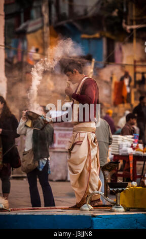 Un prêtre hindou sur les rives du Gange / Gange à Varanasi, Inde effectue une puja (cérémonie) avec lampe à huile. Banque D'Images