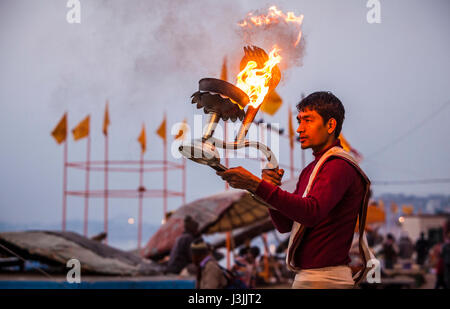 Un prêtre hindou sur les rives du Gange / Gange à Varanasi, Inde effectue une puja (cérémonie) avec une lampe à huile. Banque D'Images