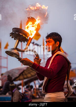 Un prêtre hindou sur les rives du Gange / Gange à Varanasi, Inde effectue une puja (cérémonie) avec une lampe à huile. Banque D'Images