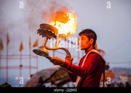 Un prêtre hindou sur les rives du Gange / Gange à Varanasi, Inde effectue une puja (cérémonie) avec une lampe à huile. Banque D'Images