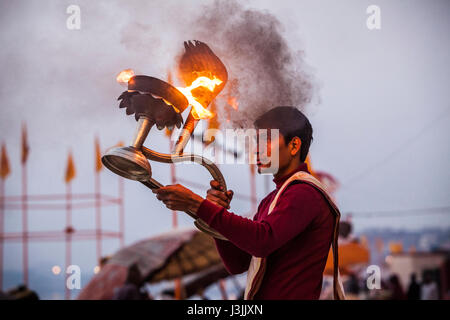 Un prêtre hindou sur les rives du Gange / Gange à Varanasi, Inde effectue une puja (cérémonie) avec une lampe à huile. Banque D'Images