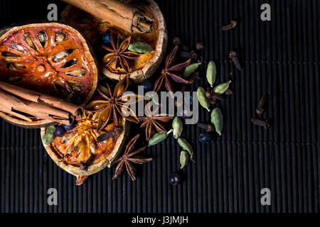 Épices réchauffement sur bambou - bâtons de cannelle, cardamome, girofle, fruit de bael, baies de genièvre et d'anis étoilé Banque D'Images