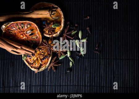 Épices réchauffement sur bambou - bâtons de cannelle, cardamome, girofle, fruit de bael, baies de genièvre et d'anis étoilé Banque D'Images