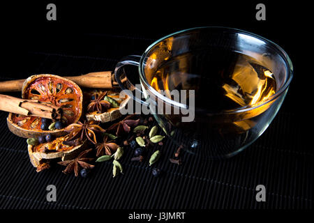 Infusion de thé et épices réchauffement sur bambou - bâtons de cannelle, cardamome, girofle, fruit de bael, baies de genièvre et d'anis étoilé Banque D'Images