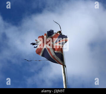 Un drapeau en lambeaux dans le vent sur la photo contre un ciel nuageux ciel bleu d'un mât en Ecosse Ballater Banque D'Images