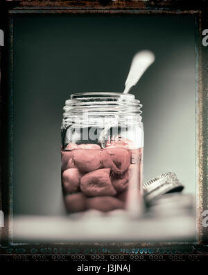 Les poivrons dans un bocal en verre avec une cuillère Banque D'Images