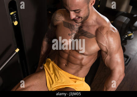 Les jambes Close Up - Homme faisant la jambe avec la machine dans une salle de sport Banque D'Images