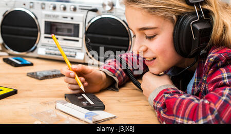 Girl listening to music on 70 boombox Banque D'Images