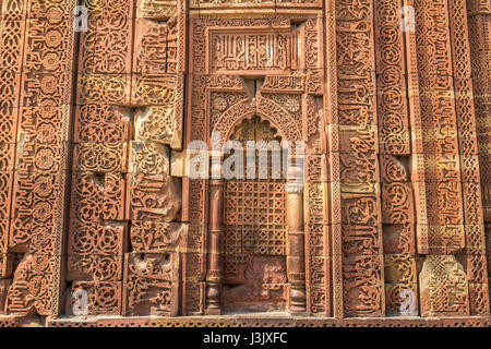 Grès rouge sculpté ancien contexte lors de la médiévale Qutb Minar.monuments historiques médiévales ruines à la forme du site Qutb Minar le qutb complexe. Banque D'Images