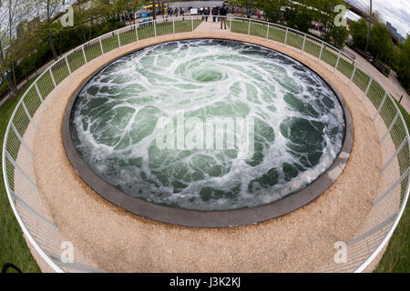 Les visiteurs du site Pont de Brooklyn Park à New York, le mercredi 3 mai 2017, sont fascinés par l'artiste Anish Kapoor's 'Descension' l'installation. L'œuvre se compose d'un vortex tournoyant continuellement de l'eau dans une piscine de 26 pieds de large, commandant les souvenirs ravivés par hypnose l'attention du spectateur comme il n'est pas sans rappeler d'être aspiré dans les profondeurs. L'installation est financée par le Public Art Fund qui célèbre son 40e anniversaire. 'Descension' sera à l'affiche jusqu'au 10 septembre 2017 sur le quai 1 dans le parc. (© Richard B. Levine) Banque D'Images