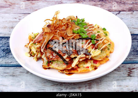 Okonomiyaki (Crêpe Chou japonais) est frit Recette farine de légumes mélangés avec de la viande garnie sauce douce ,la mayonnaise et les tranches de thon séché Banque D'Images