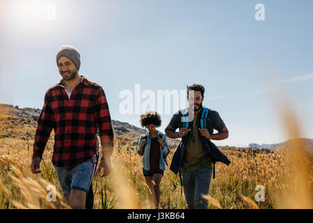 Trois jeunes amis sur un pays de marche. Groupe de personnes la randonnée à travers la campagne. Banque D'Images