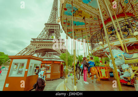 Paris, France 1 juin 2015 : Un carrousel traditionnel parisien situé à proximité de la Tour Eiffel qui est vu en arrière-plan. Banque D'Images