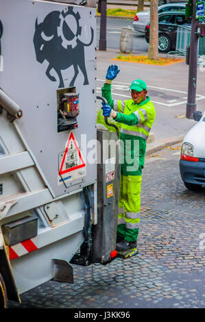 Paris, France 1 juin 2015 : camion poubelle avec un homme debout sur la partie arrière, la conduite sur les rues dans le cadre de son itinéraire quotidien. Banque D'Images