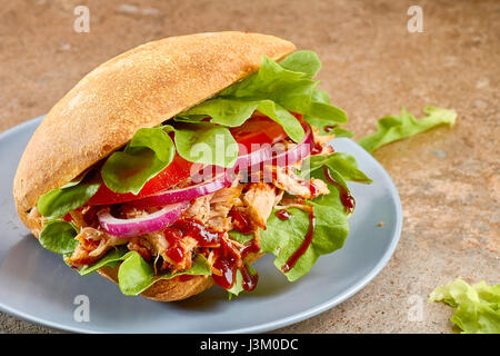 Porc sandwich avec salade, tomate et sur plat bleu Banque D'Images