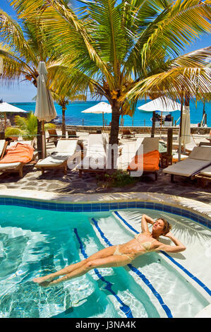 Jeune femme au soleil dans une piscine, Wicked Weasel bikini, Ile Maurice, Afrique du Sud Banque D'Images