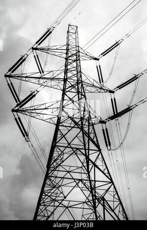 Un pylône d'électricité et les lignes électriques silhouetted against a cloudy sky Banque D'Images