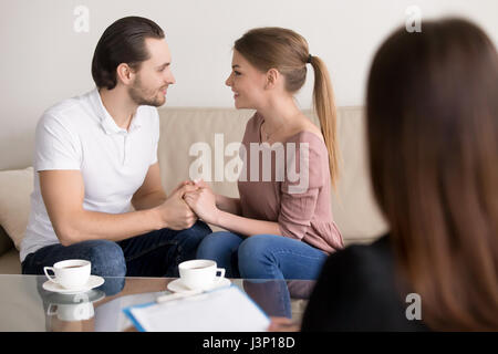 Happy smiling young couple holding hands, consulting psychologis Banque D'Images