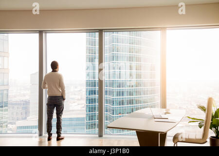 Jeune homme d'affaires réussi standing in office looking at full- Banque D'Images