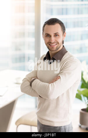 Cheerful successful businessman with arms crossed looking at cam Banque D'Images