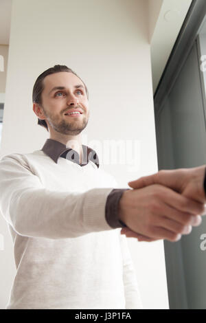 Young smiling businessman shaking hand féminin standing in office Banque D'Images