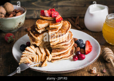 Crêpes en bonne santé. Pile de crêpes délicieux grains entiers sains avec farine d'épeautre (servi avec des fraises, bleuets, canneberges, Amandes, miel Banque D'Images