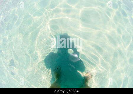 Ombre, auto-portrait, en vacances. Clair comme de l'eau de l'océan, du soleil et des pieds. Banque D'Images