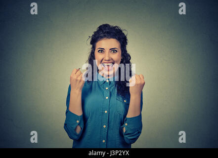 Lucky Girl. Closeup portrait jeune femme heureuse poings pompage exulte de joie isolé sur fond de mur gris. Célébrer les succès concept. Les droits de l Banque D'Images