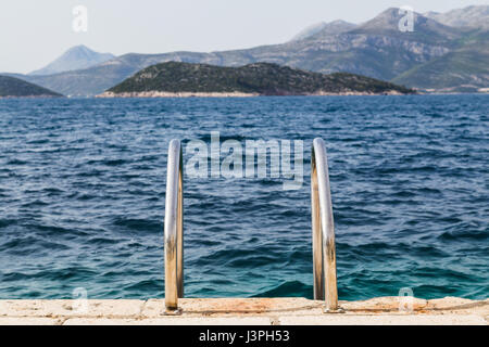 Quelques marches mènent vers le bas du quai sur l'île croate de Lopud et dans les eaux turquoises de la mer Adriatique. Banque D'Images