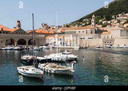 Les petits bateaux bobbling au bord de l'eau dans le vieux port de Dubrovnik. Banque D'Images