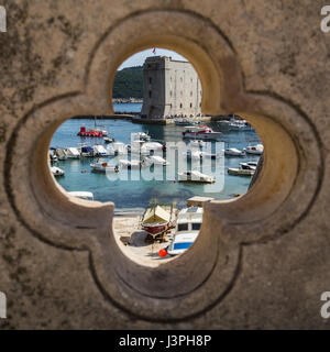 Le vieux port de Dubrovnik vue à travers une décoration sur le pont menant à la porte Ploce. Banque D'Images