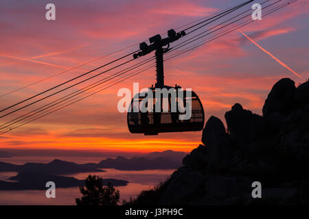 Le téléphérique navettes qui les touristes de la vieille ville de Dubrovnik sur le sommet de la colline de Srd capturé au coucher du soleil. Banque D'Images