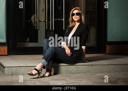 La mode jeune femme assise au centre commercial de la porte Banque D'Images