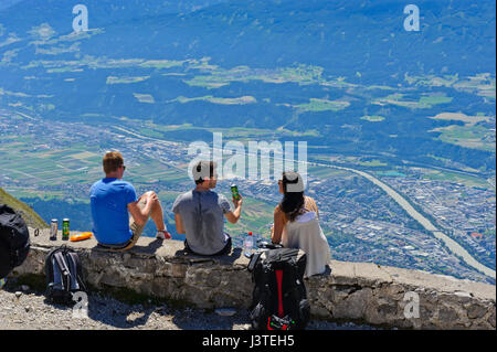 Trois amis en haut de Hafelekar à admirer la vue panoramique de l'iInnsbruck dans la vallée, Tirol, Autriche Banque D'Images