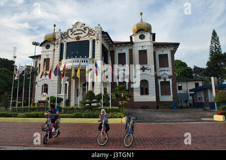 Les cyclistes en face de la proclamation de l'indépendance Memorial Museum, Malacca, Malaisie Banque D'Images