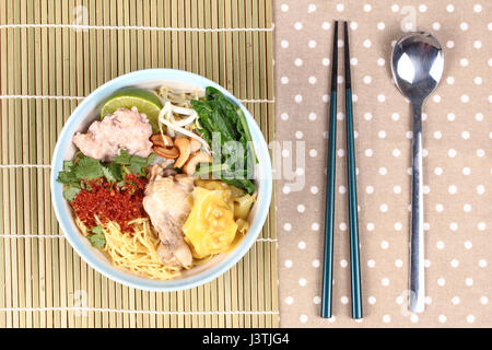 Nouilles wonton en bouillie et soupe aigre épicée comme tom yum surmontée porc haché,pilons de poulet,le piment,germes de noix de cajou,Chinois,vert moutarde et gr Banque D'Images