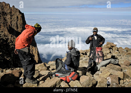 Guide et porteurs en faisant une pause sur les nuages sur l'ouest de l'infraction, Parc national du Kilimandjaro, Tanzanie Banque D'Images