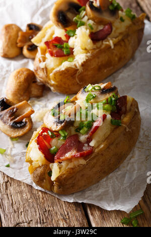 Pomme de terre au four farcies au bacon, champignons et fromage sur la table verticale. Banque D'Images