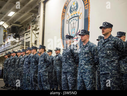 Les marins se tiennent en formation pour une inspection de l'uniforme à bord de l'USS Makin Island, un navire d'assaut amphibie, dans le cadre du Makin Island Amphibious Ready Group et de la 11e Marine Expeditionary Unit revenant d'un déploiement de sept mois dans les zones d'opérations des 3e, 5e et 7e flotte. Banque D'Images