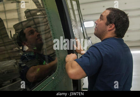 Thomas Martinez, 54e Escadron d'mécanicien d'aéronefs, ferme une porte de cabine de l'hélicoptère à Minot Air Force Base, N.D., 2 mai 2017. Les membres de l'escadron se livrent aussi à mission de recherche et de sauvetage d'urgence de la formation. (U.S. Air Force photo/Navigant de première classe Jonathan McElderry) Banque D'Images