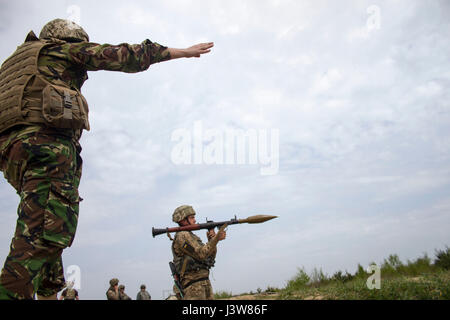 Un formateur de l'armée ukrainienne affecté à l'Entraînement au Combat de Yavoriv Centre fournit l'instructions d'allumage à un soldat avec l'Ukraine's 1st Bataillon aéromobile, 79e Brigade d'assaut aérien au cours de la formation à l'viv RPG CCT sur le maintien de la paix et la sécurité internationale, près de l'viv, Ukraine, le 4 mai. Les formateurs de la CCT, en partenariat avec des soldats de l'armée américaine 45th Infantry Brigade Combat Team, sont des troupes de l'enseignement de l'armée ukrainienne 1er Bataillon aéromobile, 79e Brigade d'assaut aérien comment employer des RPG pendant la rotation du bataillon à la CCT. La 45e IBCT est déployée dans le cadre de l'Inscrivez-vous Banque D'Images