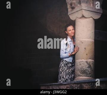 Belle femme en longue jupe posant près de l'ancienne colonne en monastère des météores en Grèce. Magnifique architecture Banque D'Images