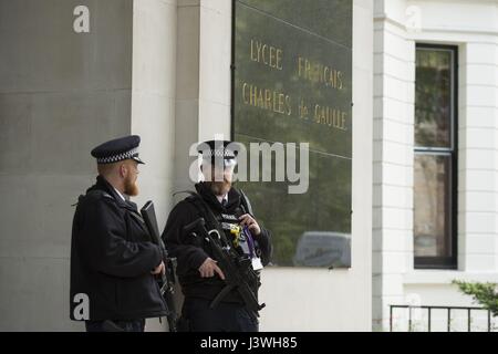 La police armée, comme électeurs expatrié se préparent à voter pour le deuxième tour de l'élection présidentielle française à un bureau de scrutin au lycee Francais Charles de Gaulle à South Kensington, Londres. Banque D'Images