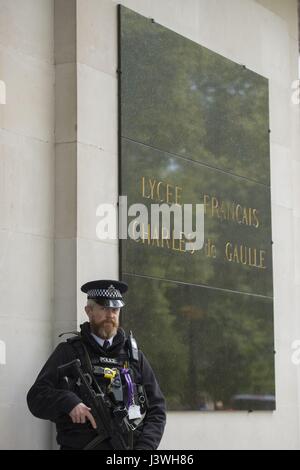 La police armée, comme électeurs expatrié se préparent à voter pour le deuxième tour de l'élection présidentielle française à un bureau de scrutin au lycee Francais Charles de Gaulle à South Kensington, Londres. Banque D'Images