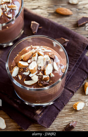 Végétalien Premières saine Mousse au chocolat garnie de verres en amande sur fond de bois close up - maison délicieux pouding au chocolat végétalien Premières avec Banque D'Images