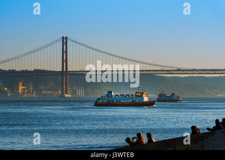 Deux bateaux à passagers (Cacilheiros) traversant le Tage à Lisbonne, Portugal, avec le Pont 25 de Abril sur l'arrière-plan Banque D'Images